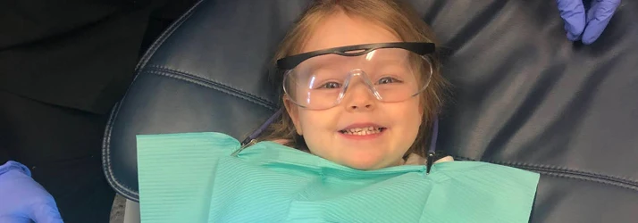 Dentist Winslow ME Pediatric Dentistry a small girl has clear goggles on and is getting ready for a dental cleaning